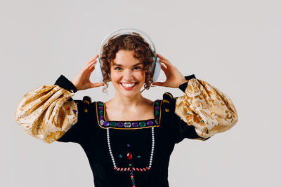 Portrait of young woman standing against white background