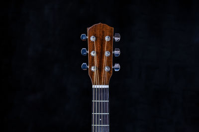 Close-up of guitar against black background