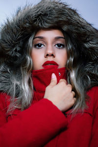 Close-up portrait of young woman wearing red warm clothing