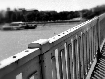 Close-up of railing by fence against blurred background