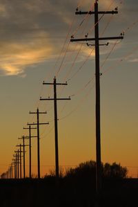 Silhouette electricity pylon against sky during sunset