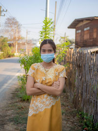 Portrait of young woman standing on field