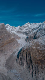 Scenic view of mountains against blue sky