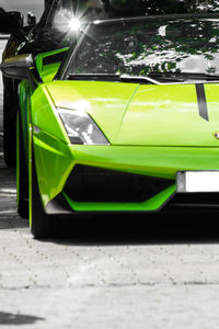 Close-up of yellow car on street