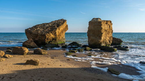 Rocks on beach against sky