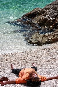 High angle view of man lying on beach