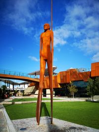 Rear view of man standing against blue sky