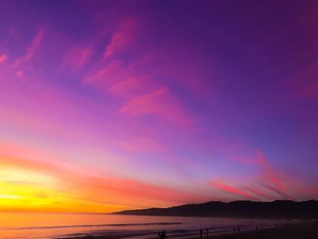 Scenic view of sea against dramatic sky during sunset