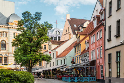 Riga, latvia cityscape. a beautiful corner of the old town. tourists relax in a cozy street cafe