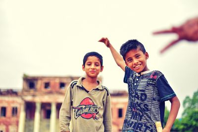 Smiling male friends against clear sky