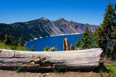 Scenic view of lake and mountains against clear blue sky