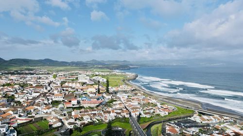 High angle view of townscape by sea against sky