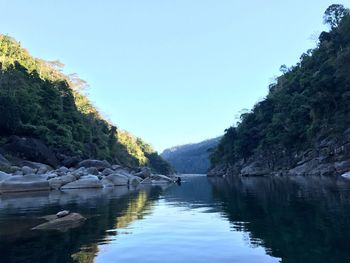 Scenic view of lake by mountains against clear sky