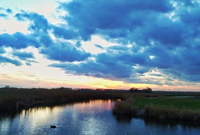 Scenic view of lake against sky at sunset