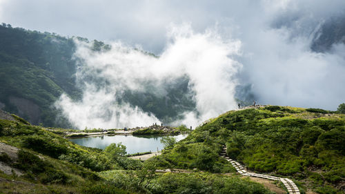 In the mountains of nagano prefecture, a heart shaped cloud formation is rising behind a pond