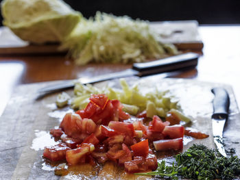 Chopped tomatoes and cilantros on cutting board in kitchen0