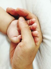 Close-up of baby hand and parent hand