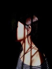 Portrait of woman wearing hat against black background