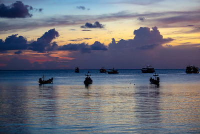 Silhouette sailboat in sea against sky during sunset