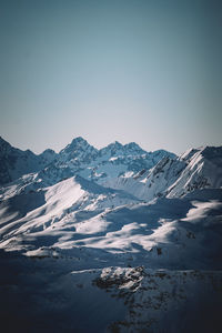 Scenic view of snowcapped mountains against clear sky