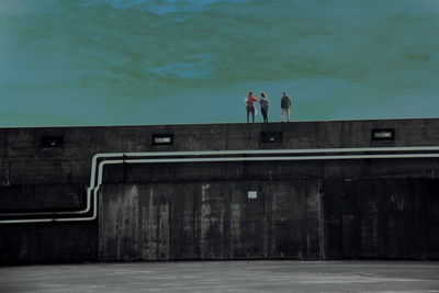 People on shore against sky