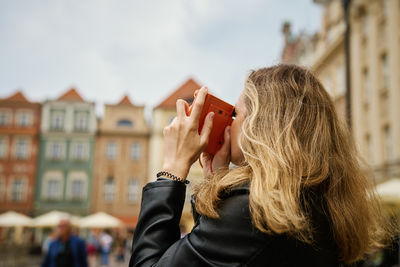 Female traveler taking picture with vintage instant camera