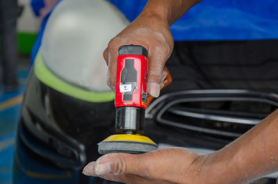 Midsection of man cleaning car at garage