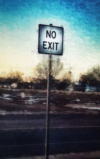 Close-up of road sign against sky