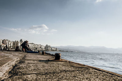 People by sea against sky