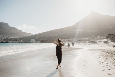 People standing on beach against sky