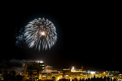 Firework display over illuminated city at night