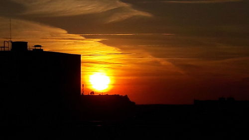 Silhouette buildings against sky during sunset