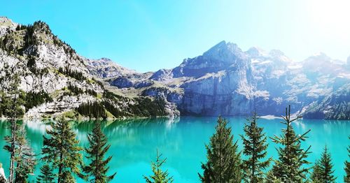 Scenic view of lake and mountains against blue sky