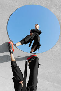 Low angle view of woman reflecting on mirror 