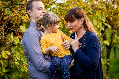 Side view of family sitting on field