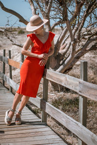 Full length of woman standing on railing