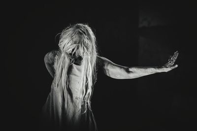 Ghost with arms outstretched against black background