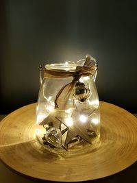 Close-up of decoration in jar on table against black background