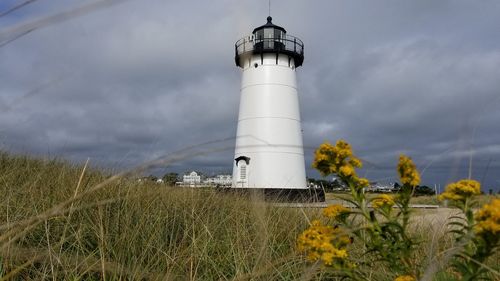 Lighthouse by sea against sky