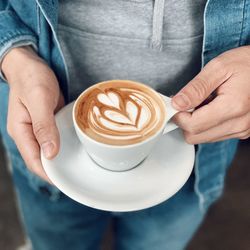 Midsection of woman holding coffee cup