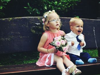 Cute baby girl and baby boy  sitting outdoors