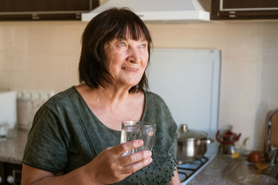 Portrait of young woman using mobile phone at home