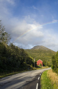 Road by trees against sky