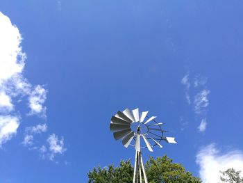 Low angle view of american-style windmill against blue sky