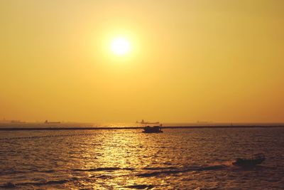 Boats in sea at sunset