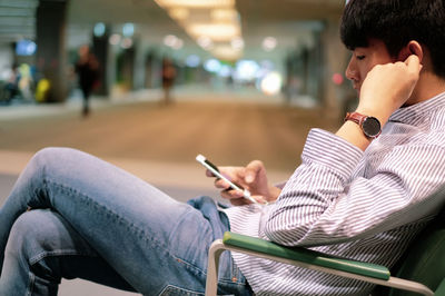 Side view of man using mobile phone