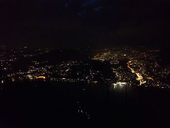 Illuminated cityscape against sky at night