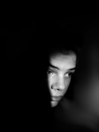 Young man looking away in darkroom