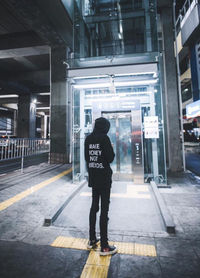 Rear view of man standing on street in city