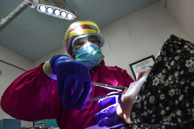 Dentist using mask and protection wear during covid-19 pandemic